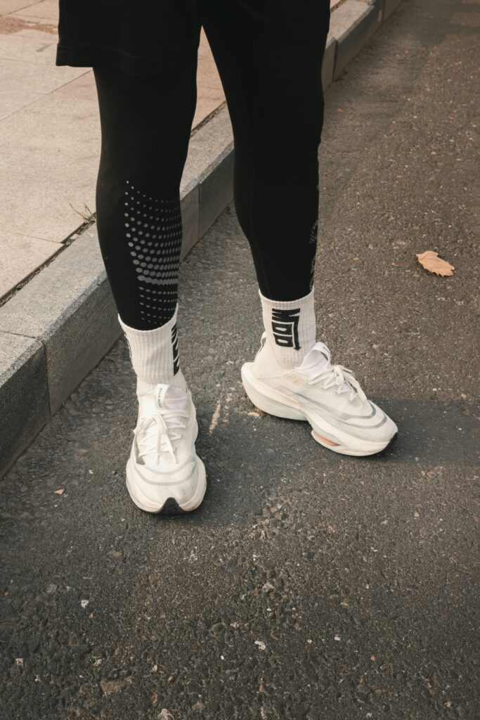 Minimal white luxury sneakers styled with tailored trousers for smart casual fashion